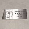 Metalinė lentelė su apskritu logotipu ir graviruota 2016 metų data.