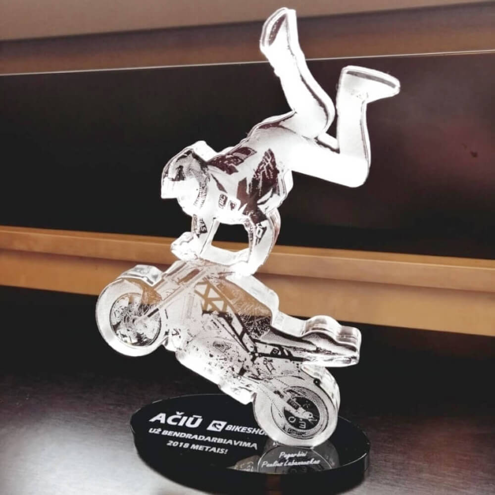 Skaidri moto sporto padėkos statulėlė su motociklininko triuko atvaizdu ant juodo stovelio.