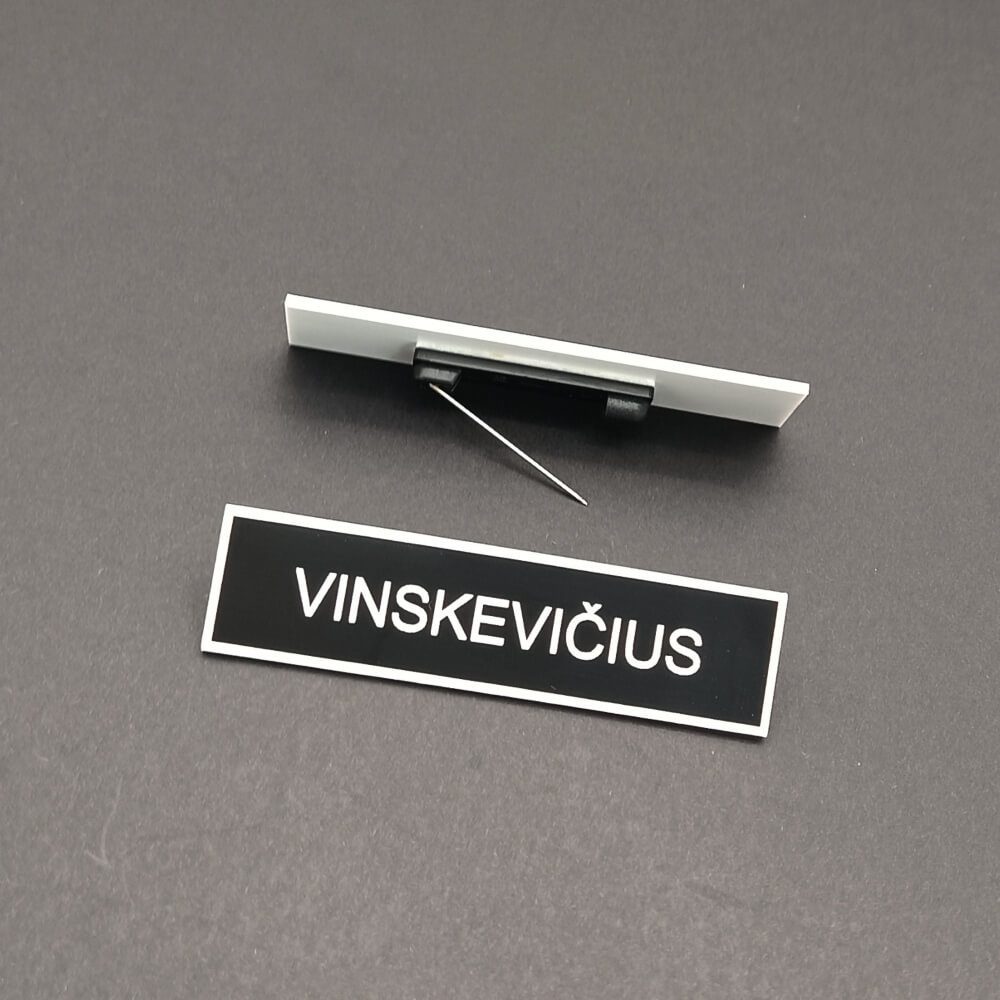 Juoda pareigūno pavardės kortelė ir tvirtinimo žiogelis