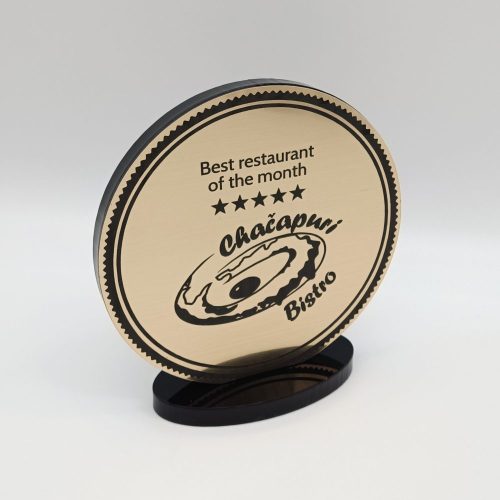 Apvali geriausio mėnesio restorano statulėlė su bistro logotipu ant juodo pagrindo