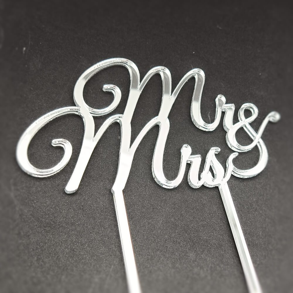 Sidabro spalvos vestuvinio torto dekoracija su užrašu „Mr & Mrs“.
