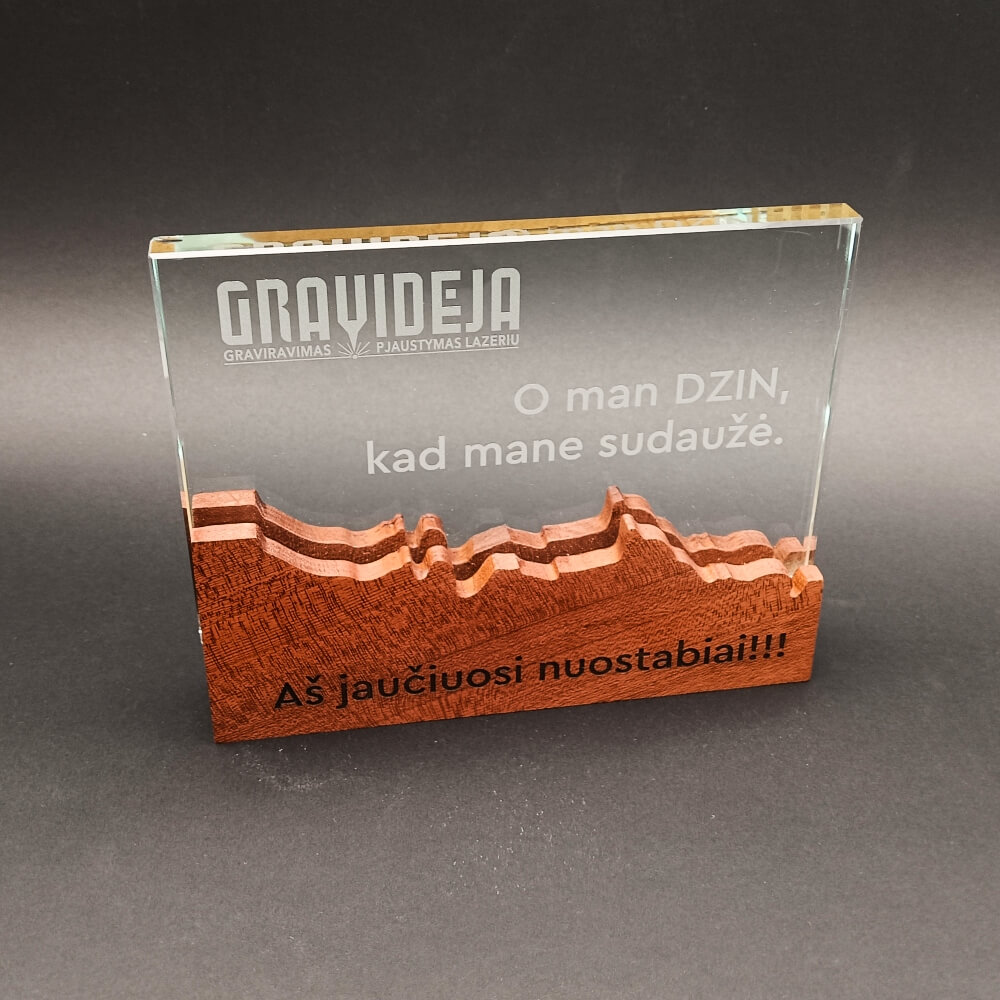 Graviruota GRAV-04 stiklo plokštelė su „Gravidėja“ logotipu ir tekstu ant raižyto medinio pagrindo.
