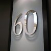 Veidrodinio paviršiaus buto numeris 60 ant durų.