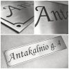 Metalinė gatvės pavadinimo lentelė „Antakalnio g. 4“ ir jos detalių vaizdai.