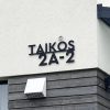 Juodas išpjautas adreso užrašas „Laikos 2A-2“ ant namo fasado.