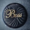 Tamsaus gimtadienio torto dekoracija su aukso spalvos užrašu „Boss“.