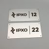 Dvi metalinės durų lentelės su logotipu ir numeriais 12 bei 22.