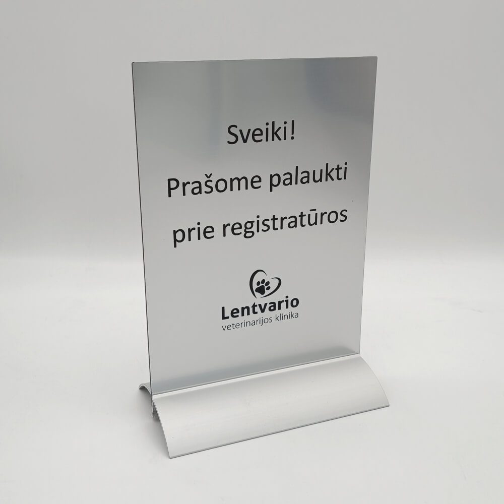 Registratūros stovelis su užrašu „Prašome palaukti“