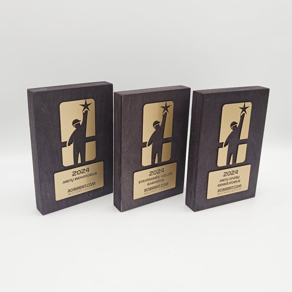 Trys tamsios plaketės su aukso spalvos žmogaus siluetu ir metų nominacijomis.