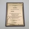 Padėkos mokytojai Aušrai plaketė su juodu augaliniu ornamentu tamsiame rėmelyje.