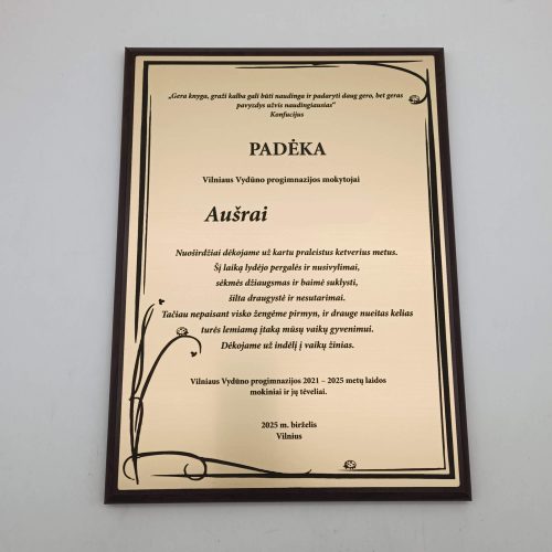 Padėkos mokytojai Aušrai plaketė su juodu augaliniu ornamentu tamsiame rėmelyje.