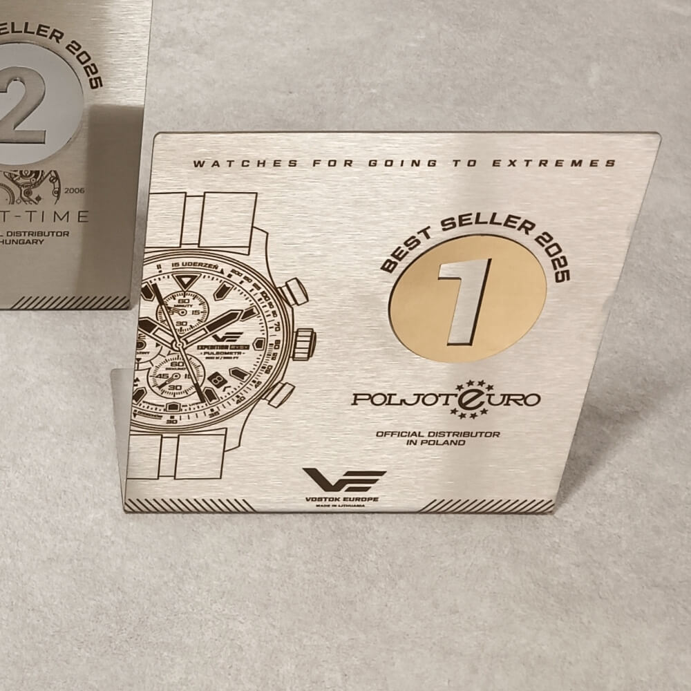 Metalinė pirmos vietos „Best Seller 2025“ plaketė su laikrodžio piešiniu ir aukso atspalvio skaičiumi.