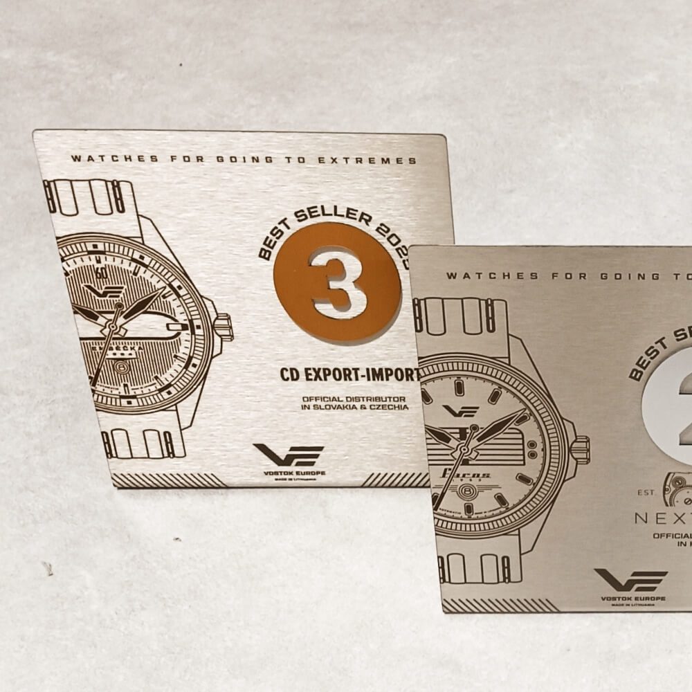 Metalinė trečios vietos „Best Seller 2025“ plaketė su laikrodžio piešiniu ir bronzos atspalvio skaičiumi.