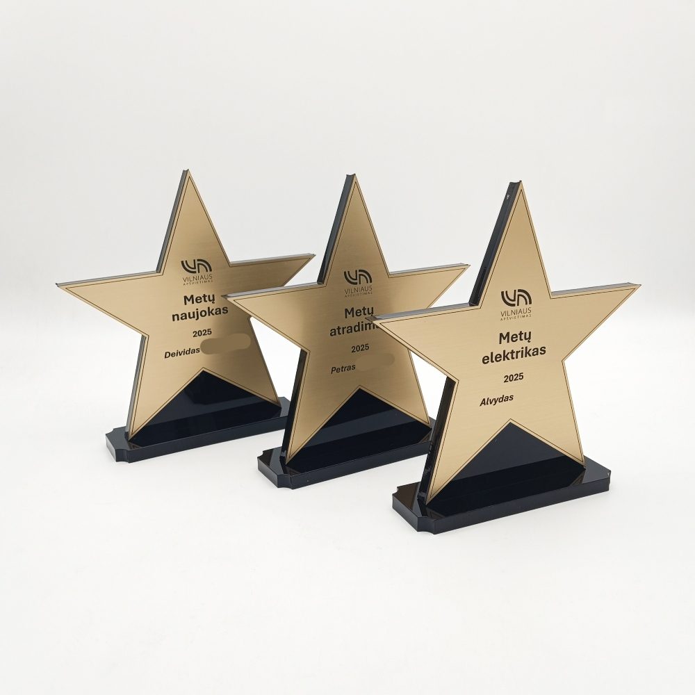 Trys aukso spalvos žvaigždės statulėlės ant juodų pagrindų su skirtingomis metų nominacijomis.