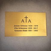 Aukso spalvos antkapio lentelė su kelių žmonių vardais ir datomis.