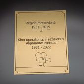 Aukso spalvos atminimo lentelė su vardu ir kino kameros piešiniu.