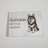 Šuns Gučiuko atminimo lentelė su graviruotu atvaizdu ir datomis.