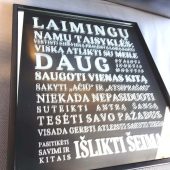Juodame rėme įrėmintas veidrodis su išgraviruotomis namų taisyklėmis