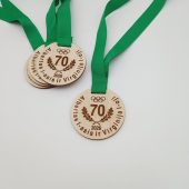 Šviesaus medžio jubiliejiniai medaliai su skaičiumi 70 ir žaliomis juostelėmis.