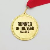 Aukso atspalvio apvalus „Runner of the Year“ medalis su raudona juostele.
