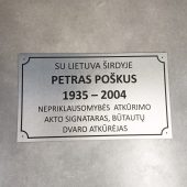 Atminimo lentelė su Petro Poškaus vardu, gyvenimo datomis ir dedikacija.