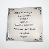 Vertikali antkapio lentelė su dviem vardais, datomis ir puošniu rėmeliu.