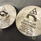 Apvalūs metaliniai talpyklų dangčiai su radioaktyvumo simboliais ir pažymėtais duomenimis