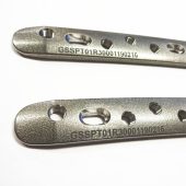 Dvi metalinės detalės su lazeriu pažymėtais serijos numeriais